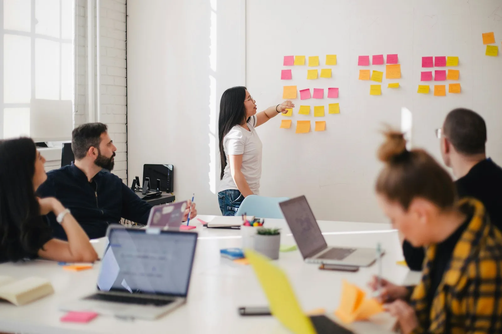 A team mapping product scope on a wall of colourful notes during a solution workshop
